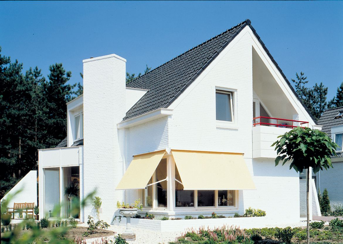 Een wit vrijstaand huis met zonneschermen