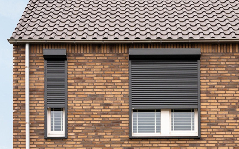 Antracieten rolluiken tegen ramen huis