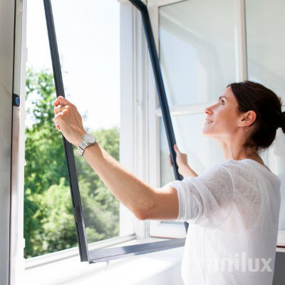 Vrouw monteert een raam in haar huis