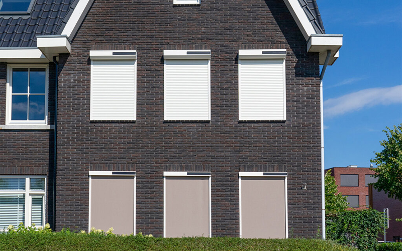 Witte rolluiken tegen huis